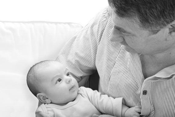 Black and white baby portrait with grandad.