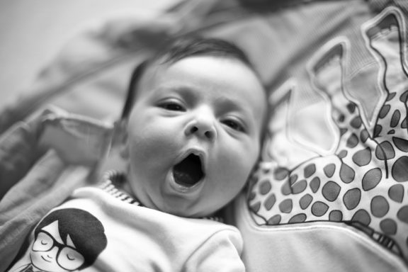 Portrait of a baby yawning.