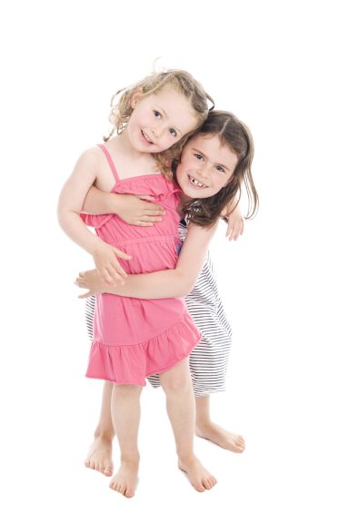 Photograph of two sisters hugging and smiling.